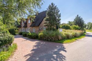 a large brick house with a driveway at Westmarken Reetdachhaus Strandkontor in Sankt Peter-Ording