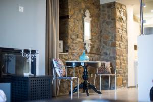 a table and chairs in a room with a stone wall at Nephelis Heritage House in Moúdhros +22 photos