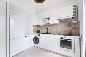 a white kitchen with a sink and a dishwasher at La Terrasse de l'Eglise, Paris Center & Eurostar 15 mn, Brand new duplex with terrasse, balcony, 2 bathrooms, parking, in Saint-Denis