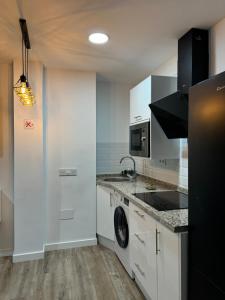 a kitchen with white cabinets and a sink and a dishwasher at Linerlife in Málaga +13 photos