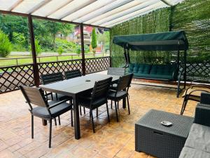 een terras met een tafel, stoelen en een bank bij Serenity Suite in Sinaia +15 foto's