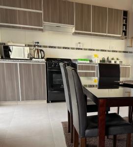 a kitchen with a table with chairs and a stove at Departamento en Mendoza in Guaymallen