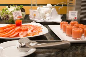 a table with plates of food and a plate of fruit at Hotel Albufera in Alfafar