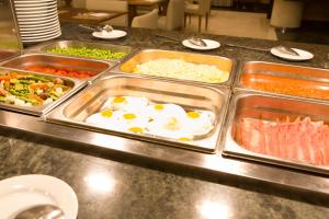 a buffet line of food with eggs and other foods at Hotel Albufera in Alfafar