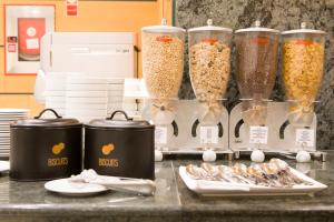 a counter with four tall containers of oats and food at Hotel Albufera in Alfafar