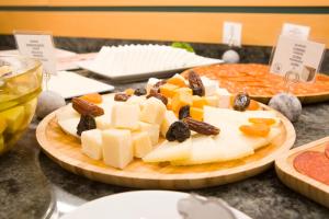 a plate of cheese and fruit on a table at Hotel Albufera in Alfafar