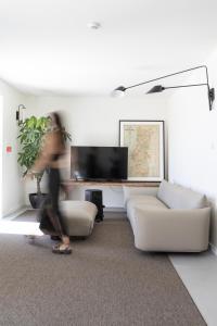 a woman walking in a living room with a couch at Casa da Milheira - Agroturismo in Oliveira de Azemeis