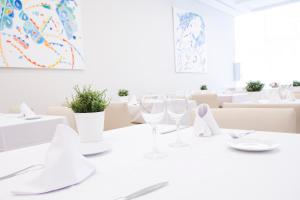 a white dining room with white tables and chairs at Hotel Albufera in Alfafar