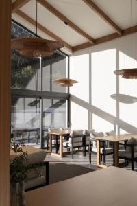 a restaurant with tables and chairs and large windows at Casa da Milheira - Agroturismo in Oliveira de Azemeis