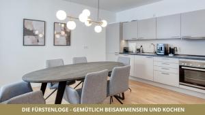 Una cocina con mesa de comedor y sillas. en NEU FEWO FUERSTENLOGE 1-6 Pers hinter dem Markgräflichen Opernhaus - 2 Schlafzimmer mit Boxspringbetten 4 Einzel oder 2 Doppelbetten, Balkon und Einbauküche, Barrierearm, en Bayreuth