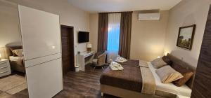 a small hotel room with a bed and a desk at Oliane Rooms & Accommodation in Bribir
