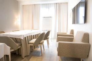 a dining room with a white table and chairs at Hotel Albufera in Alfafar