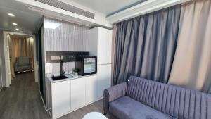 a living room with a couch and a television at Glam Beach Resort in Baku