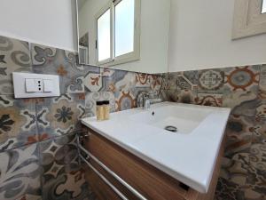 a bathroom with a white sink and a mirror at Mamalù Deluxe in Lampedusa