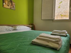 a green bed with towels sitting on top of it at Mamalù Deluxe in Lampedusa
