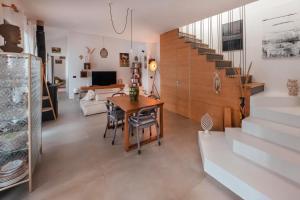 a dining room and living room with a table and stairs at Villa Andrea in Cefalù