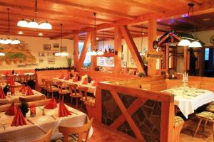 a restaurant with white tables and chairs and wooden walls at Landgasthof Frankentor in Wasserlosen