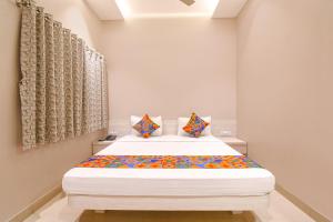 Un dormitorio con una cama grande en una habitación. en FabHotel Kitchen Q Inn - Belaghata, en Calcuta