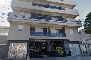 圣地亚哥-德尔埃斯特罗Edificio Céntrico的一座白色的大楼，前面有一块招牌