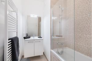 a white bathroom with a shower and a sink at La Terrasse de l'Eglise, Paris Center & Eurostar 15 mn, Brand new duplex with terrasse, balcony, 2 bathrooms, parking, in Saint-Denis