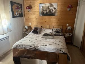 a bedroom with a bed with a wooden wall at La Taniere in Blachière