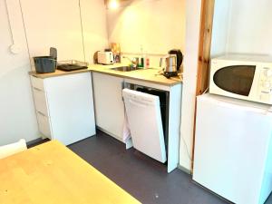 a small kitchen with a microwave and a refrigerator at Villa Win in Lappeenranta