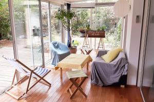 a room with chairs and a table and a room with a window at Villa avec jardin et piscine privés in Montpellier