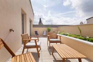 a patio with chairs and tables on a balcony at La Terrasse de l'Eglise, Paris Center & Eurostar 15 mn, Brand new duplex with terrasse, balcony, 2 bathrooms, parking, in Saint-Denis +10 photos