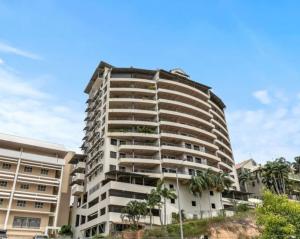 a tall building with palm trees in front of it at Holiday at Harry Chan Darwin CBD Location Plus in Darwin