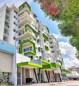 a large apartment building with green and white balconies at Absolute Hidden Gem in CBD in Darwin