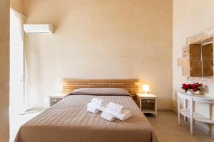 a bedroom with a bed with towels on it at Case Mediterranee in Modica