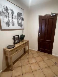 a room with a wooden table and a door at Darwin Esplanade Walk to Waterfront Wines and Waves in Darwin