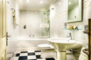 a bathroom with a sink, toilet and bathtub at Mansion House Hotel in Elgin