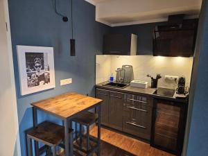 a small kitchen with a wooden table and a counter at Pension Flughafen Leipzig in Freiroda