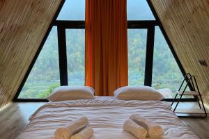a bed in a room with a large window at Green Villa Resort Orange in Dilijan