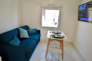 Una sala de estar con un sofá azul y una mesa. en Almar Studio - Albufeira - Praia dos pescadores, en Albufeira