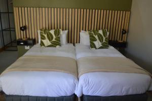 two beds sitting next to each other in a room at Uitsig Boutique Hotel in Welkom