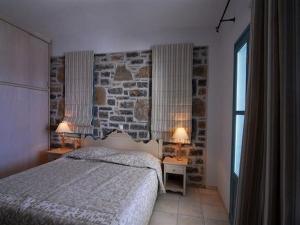 sypialnia z łóżkiem i kamienną ścianą w obiekcie Deluxe Crete Villa Villa Mousses 2 Bedroom Villa Private Pool Sea View Sitia w mieście Mochlos