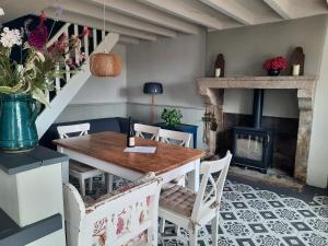 a dining room with a table and a fireplace at Gîte La Boutardière in Saint-Aubin-le-Cloud +25 photos