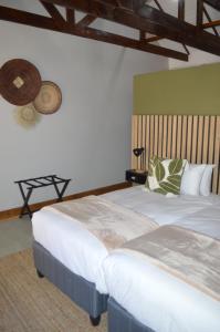 a bedroom with two beds and a fan on the wall at Uitsig Boutique Hotel in Welkom