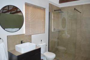 a bathroom with a toilet and a sink and a shower at Uitsig Boutique Hotel in Welkom