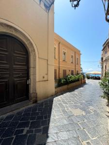 a building with a brown door and a street at Mare Fuori Apartment in Tropea