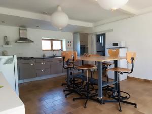 a kitchen with a table and chairs in a room at Gites de la Bénardière in Vallières-les-Grandes +23 photos