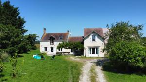 an old house with a dirt road in front of it at Gites de la Bénardière in Vallières-les-Grandes