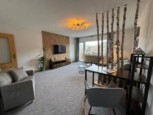 a living room with a couch and a table and a television at Ferienwohnung am alten Weinberg in Bad Berleburg