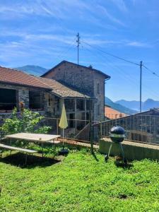 a yard with a table and a grill and a building at Romantic Apartment Sonvico in Lugano