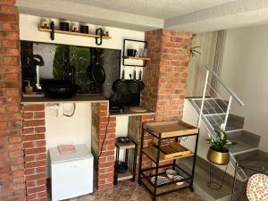 a kitchen with a brick wall and a shelf with pots and pans at Sebe apartments 4 in Holíč