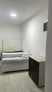 a bedroom with a bed and a wooden cabinet at Casa Haidu in 2 Mai