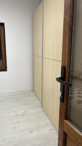 a room with a door and a room with a wooden floor at Casa Haidu in 2 Mai