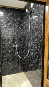 a bathroom with a shower with a black tiled wall at Casa Haidu in 2 Mai +1 photo